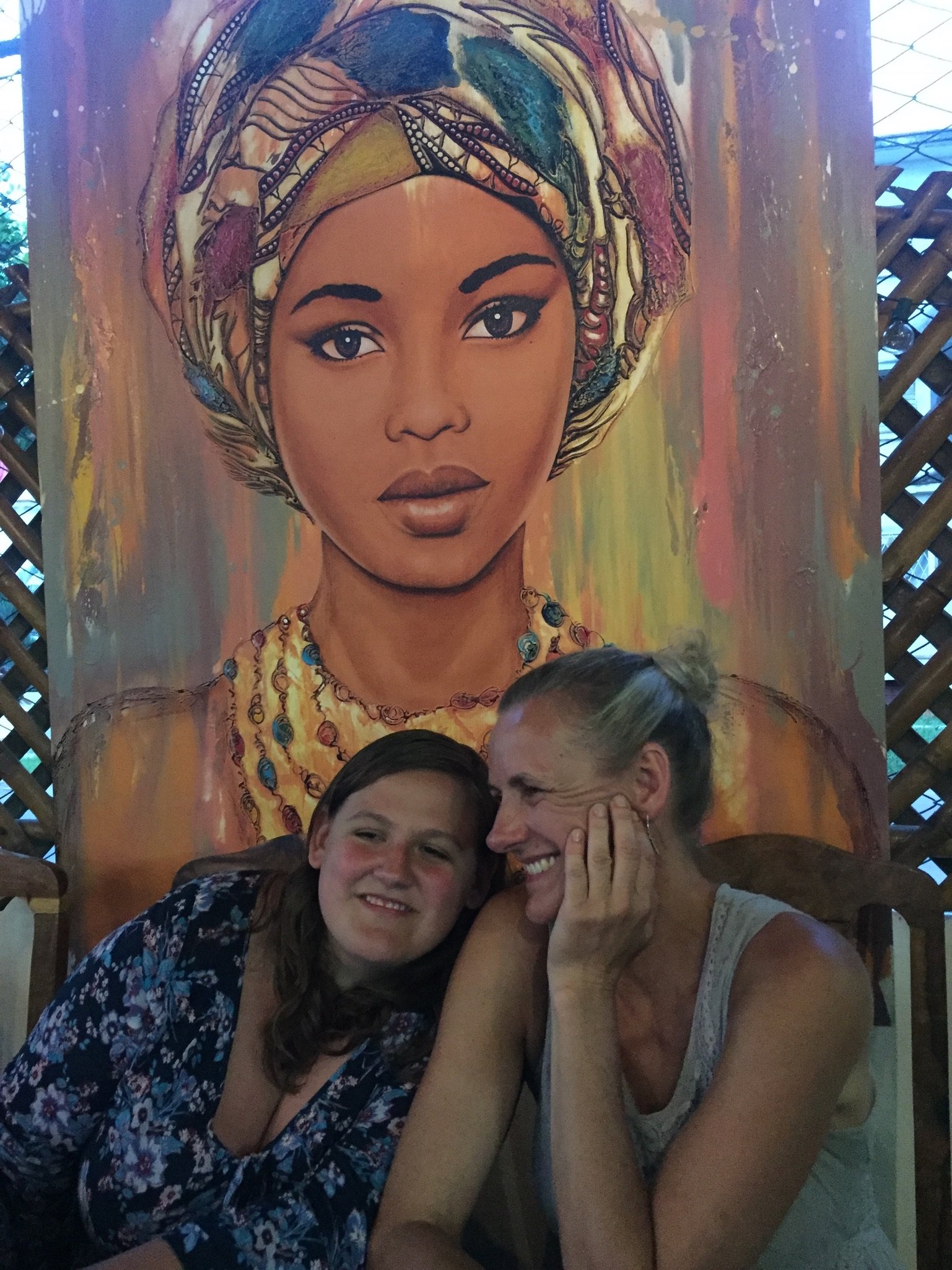 Friends sitting and smiling with giant painting background