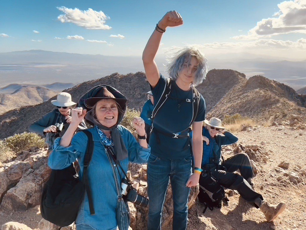 Friends hiking and standing with their fists in the air